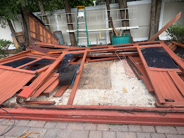 Light demolition shed teardown with wood panels and debris ready for haul-away on Long Island