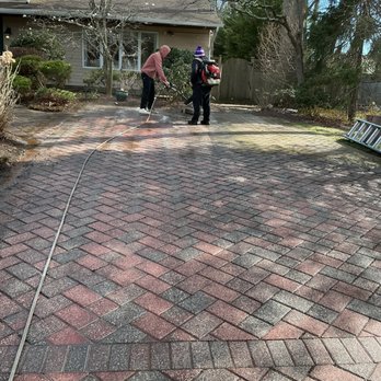 Professional power washing and soft washing of a brick paver driveway on Long Island New York